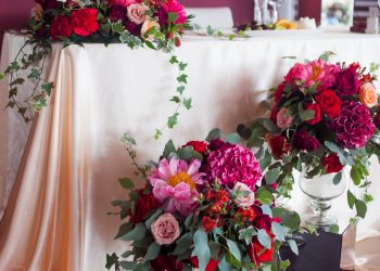 Wedding decor. decor of the newlyweds. Silk tablecloths, red flowers